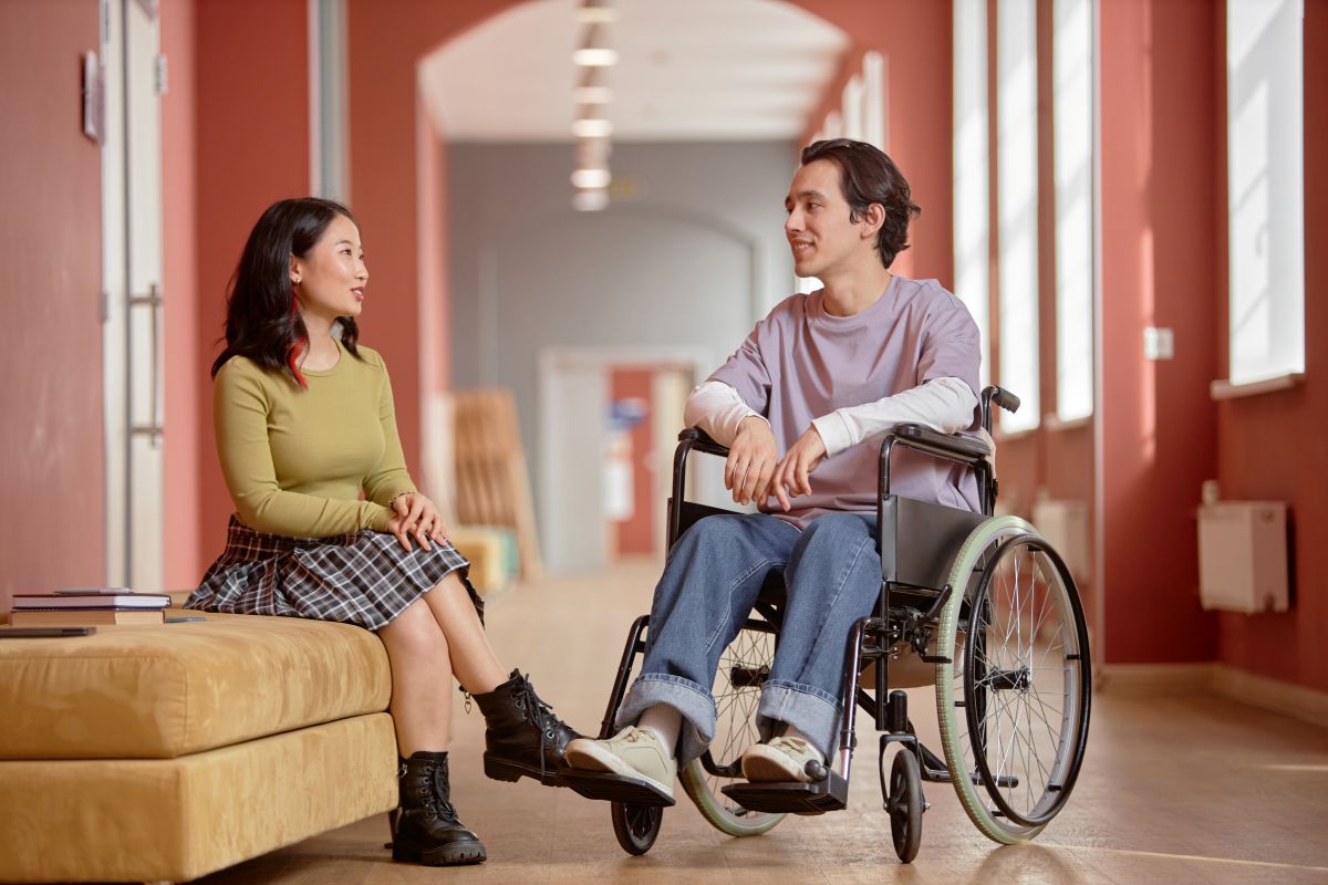 Ontario Legislative Building at Queen's Park, Toronto, Canada Two people chatting, one of them is a wheelchair user.